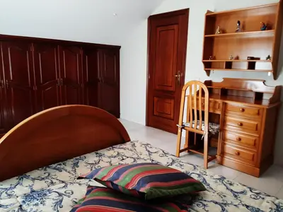 a bedroom with a bed and a wooden desk at Apartamento AS CARBALLAS in Caldas de Reis