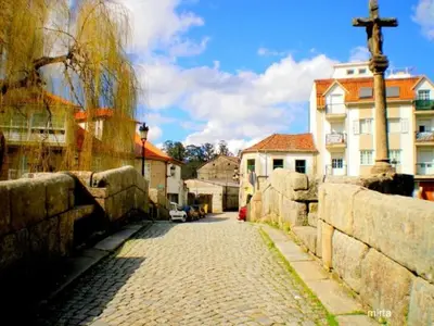 a cobblestone street in a town with a church at Apartamento AS CARBALLAS in Caldas de Reis