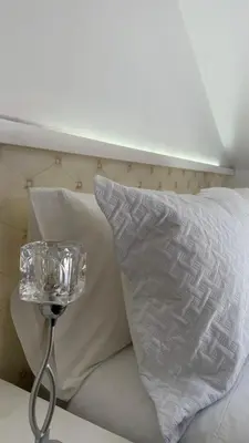 a bed with a white pillow and a wine glass at Alfonso Vll in Caldas de Reis