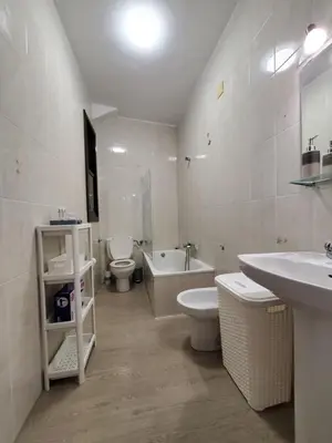 a bathroom with two toilets and a tub and a sink at Piso termal III in Ourense