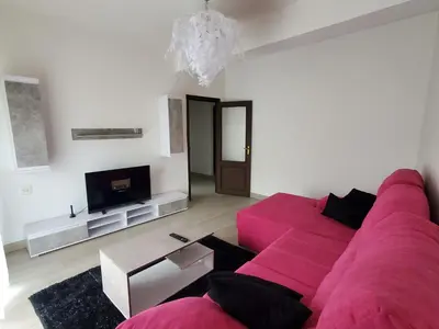 a living room with a pink couch and a tv at Piso termal III in Ourense