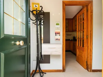 a room with a green door and a tripod next to a kitchen at Apartment near Santiago de Compostela in Eirapedriña