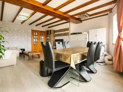 a dining room with a wooden table and leather chairs at Apartment near Santiago de Compostela in Eirapedriña