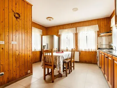 a kitchen with a table and chairs and wooden walls at Apartment near Santiago de Compostela in Eirapedriña