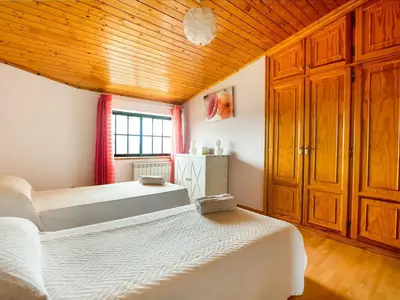 a bedroom with two beds and a wooden ceiling at Apartment near Santiago de Compostela in Eirapedriña