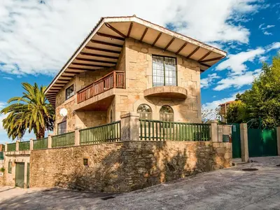 a stone house with a balcony on a wall at Apartment near Santiago de Compostela in Eirapedriña