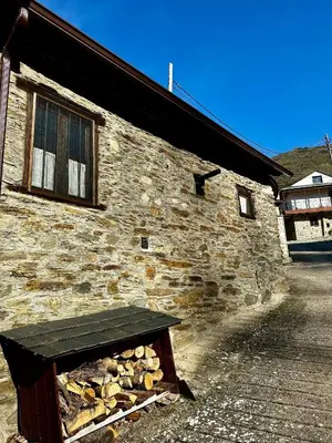 a stone building with a bench in front of it at Casa Folibar in Manzanedo de Valdueza