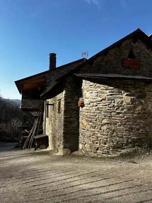 a stone building with a roof on a dirt road at Casa Folibar in Manzanedo de Valdueza