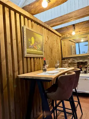 a wooden wall with a table and two chairs at Casa Folibar in Manzanedo de Valdueza