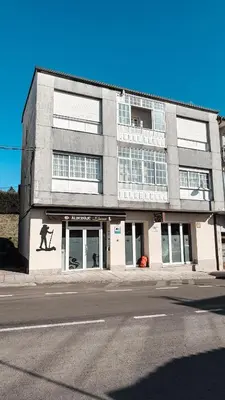 a building with a mural of a man on the side of it at Albergue Lecer Sobrado in Porta