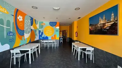 a dining room with tables and chairs and a mural at Albergue Lecer Sobrado in Porta