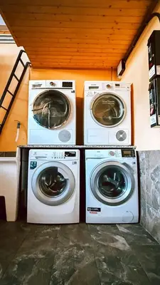 two washing machines and a washer and dryer in a room at Albergue Lecer Sobrado in Porta