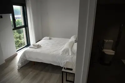 a bedroom with a white bed and a window at Hotel Chips Fene in Fene