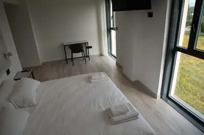 a white bed in a room with a window at Hotel Chips Fene in Fene