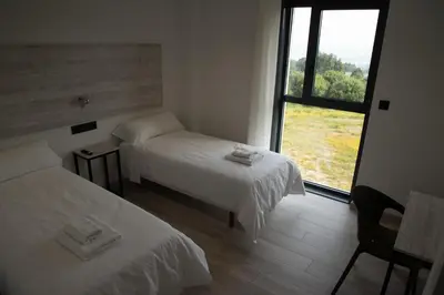 a room with two beds and a large window at Hotel Chips Fene in Fene