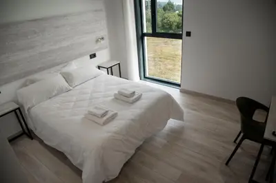 a bedroom with a white bed with two towels on it at Hotel Chips Fene in Fene