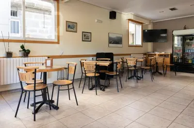 a dining room with tables and chairs in a restaurant at A Pousa Pensión rural (Camino de Santiago Sanabrés) in Armariz