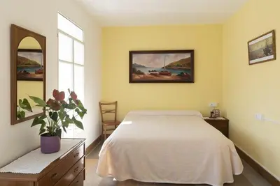 a bedroom with a white bed and a window at A Pousa Pensión rural (Camino de Santiago Sanabrés) in Armariz