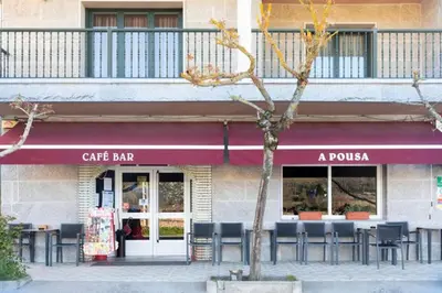 a cafe bar with tables and chairs in front of a building at A Pousa Pensión rural (Camino de Santiago Sanabrés) in Armariz