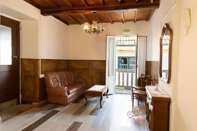 a living room with a leather couch and a chair at A Pousa Pensión rural (Camino de Santiago Sanabrés) in Armariz