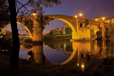 an old bridge over a river at night at Piso Estación Termal GARAJE Y AIRE ACONDICIONADO in Ourense