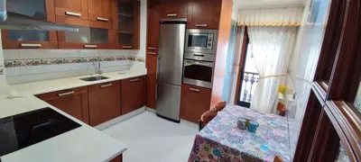 a kitchen with wooden cabinets and a counter top at Piso Estación Termal GARAJE Y AIRE ACONDICIONADO in Ourense