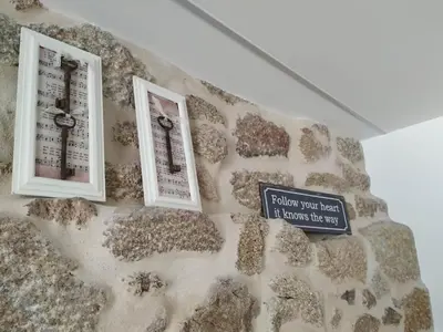 a wall with two windows and a sign on it at O Berce Padrón casa rural in Padrón