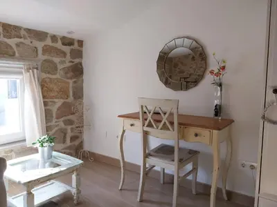 a room with a desk and a chair and a mirror at O Berce Padrón casa rural in Padrón