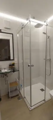 a shower in a bathroom with a sink and a mirror at O Berce Padrón casa rural in Padrón