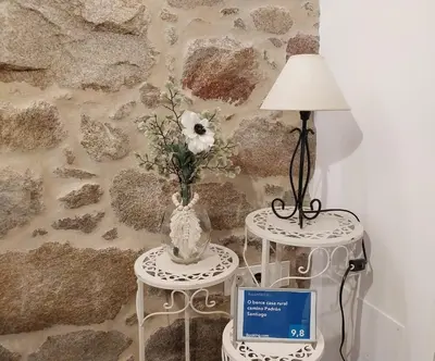 a couple of tables with a vase and a lamp at O Berce Padrón casa rural in Padrón