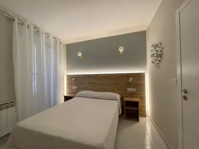 a bedroom with a white bed and a window at Grupo Las Catedrales - Hotel Amadora in Barreiros