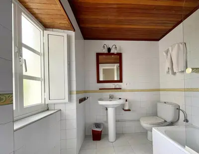 a white bathroom with a sink and a toilet at Grupo Las Catedrales - Hotel Amadora in Barreiros