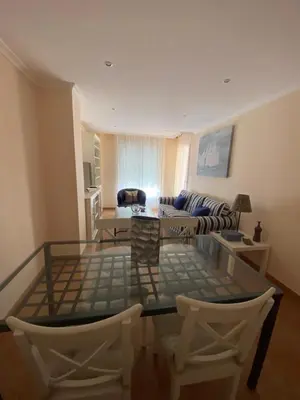 a living room with a glass table and chairs at Apartamento Marexada Foz in Foz