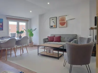 a living room with a couch and a table and chairs at Apartamentos Rey by Como en Casa in Santiago de Compostela