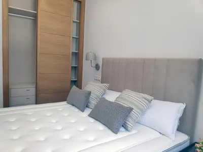 a white bed with two pillows on top of it at Apartamentos Rey by Como en Casa in Santiago de Compostela