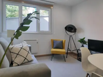 a living room with a couch and a chair at Apartamentos Rey by Como en Casa in Santiago de Compostela