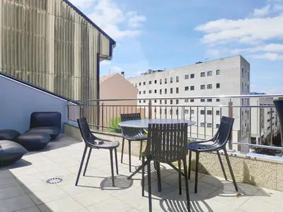 a patio with a table and chairs on a balcony at Apartamentos Rey by Como en Casa in Santiago de Compostela