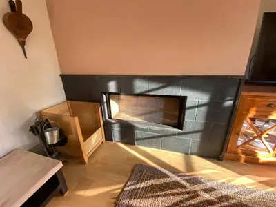 a living room with a fireplace in the corner at Casa Loureal Ribeira Sacra Ourense in Ourense