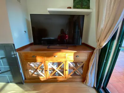 a flat screen tv on top of a wooden entertainment center at Casa Loureal Ribeira Sacra Ourense in Ourense