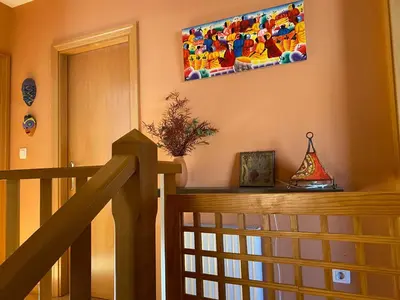 a wooden staircase with a painting hanging on the wall at Casa Loureal Ribeira Sacra Ourense in Ourense