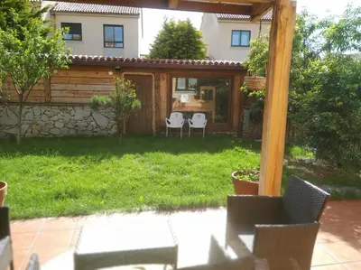 a garden with two chairs and a house at Casa Loureal Ribeira Sacra Ourense in Ourense