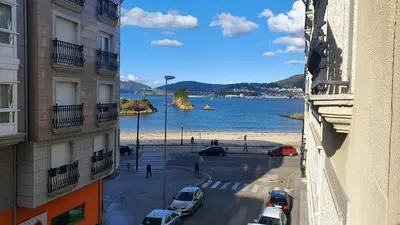 a view of a beach from between two buildings at Os Castelos Playa de Covas in Viveiro