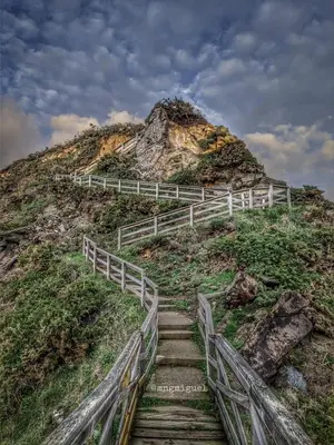 a staircase leading up to a hill with a fence at Os Castelos Playa de Covas in Viveiro