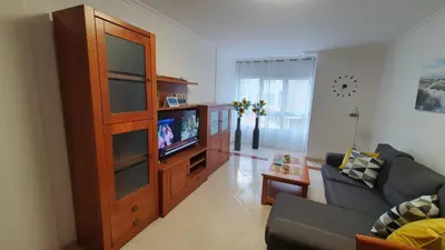 a living room with a large wooden entertainment center at Os Castelos Playa de Covas in Viveiro