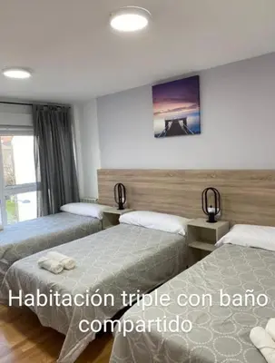 a hotel room with two beds and a window at Pension Ameneiral in O Pedrouzo