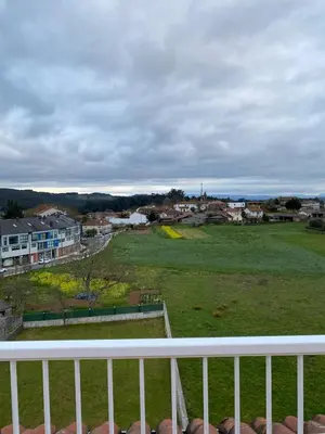 a view of a green field from a balcony at Pension Ameneiral in O Pedrouzo