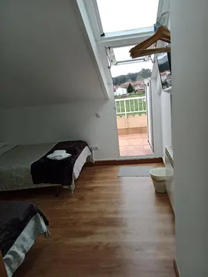 a bedroom with a bed and a large window at Pension Ameneiral in O Pedrouzo