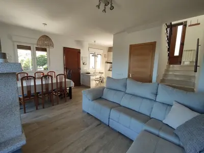 a living room with a blue couch and a kitchen at CASA RURAL PAJARICA en Sanabria in San Ciprián