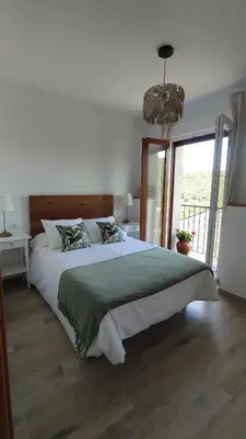 a bedroom with a large bed and a large window at CASA RURAL PAJARICA en Sanabria in San Ciprián
