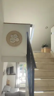 a staircase in a living room with a couch at CASA RURAL PAJARICA en Sanabria in San Ciprián